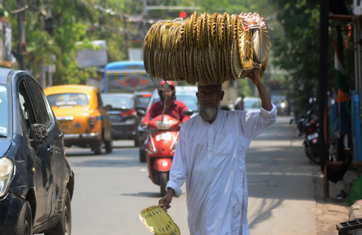 গরমে চাহিদা তুঙ্গে হাত পাখার মাথায় তালপাতার পাখা নিয়ে এক বিক্রেতা